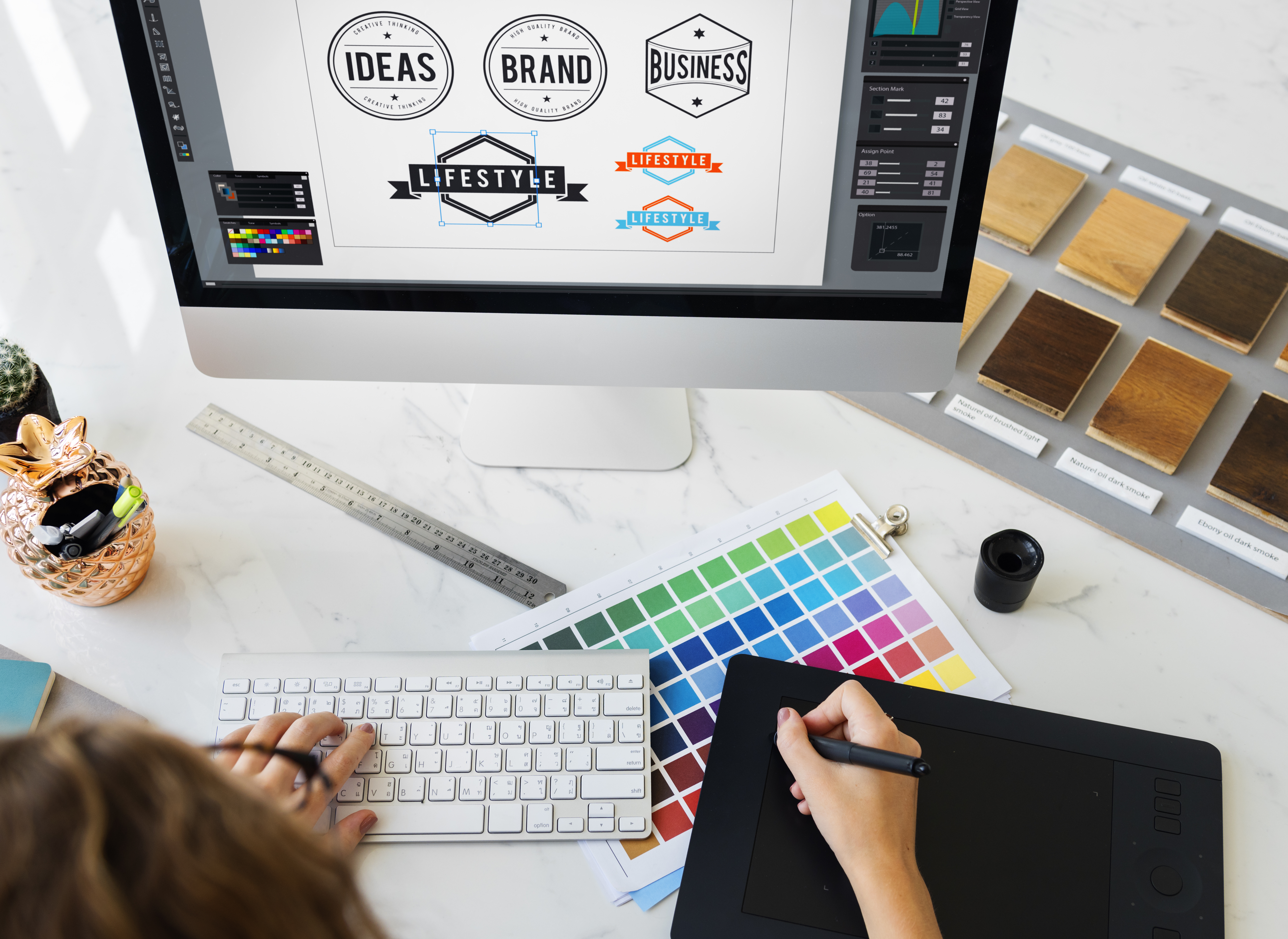 Grafica che sta definendo la palette colori per il logo davanti a un iMac