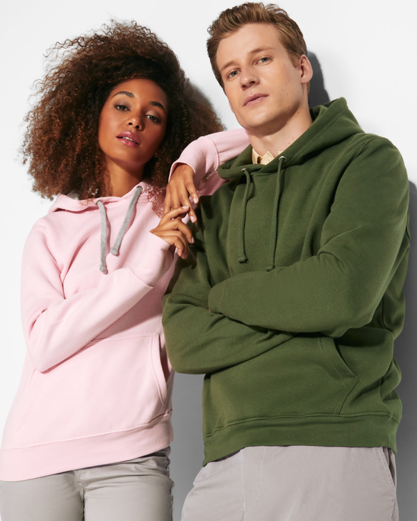 Due giovani che indossano felpa con cappuccio. Ragazzo biondo con felpa verde e ragazza con felpa rosa con lacci grigi